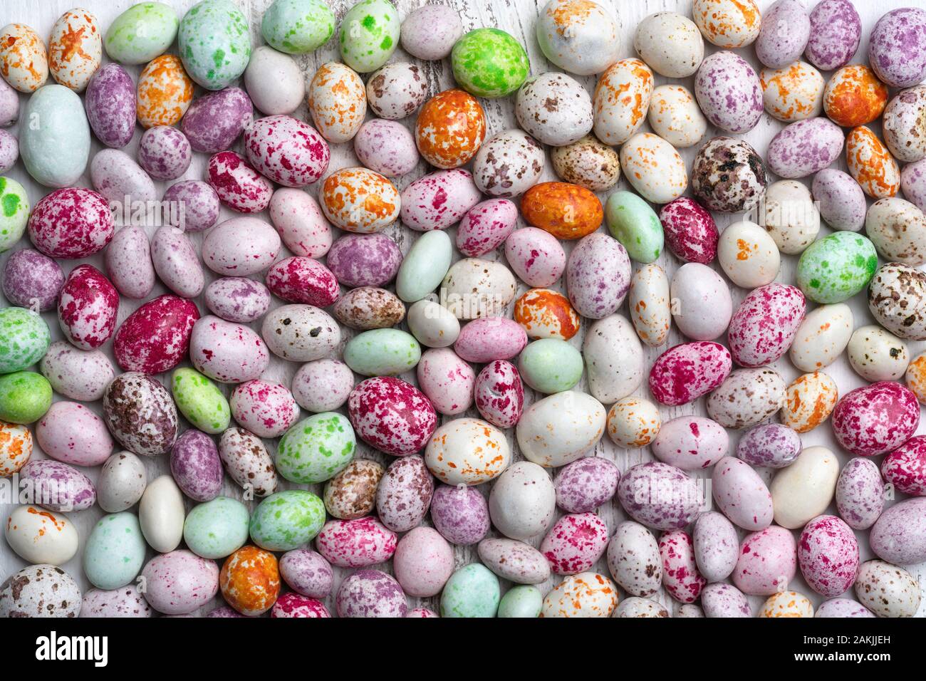 Mix of sweets in the form of multi-colored spotted pebbles on a white background. A high resolution. Stock Photo
