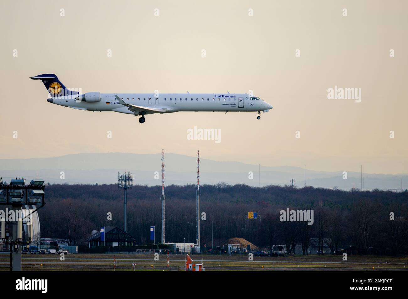 Lufthansa Cityline Bombardier CRJ 700 aircraft coming in to land at Frankfurt airport in Germany at sunset Stock Photo