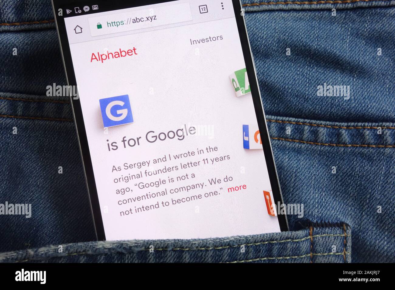 Alphabet Inc. website displayed on smartphone hidden in jeans pocket Stock Photo