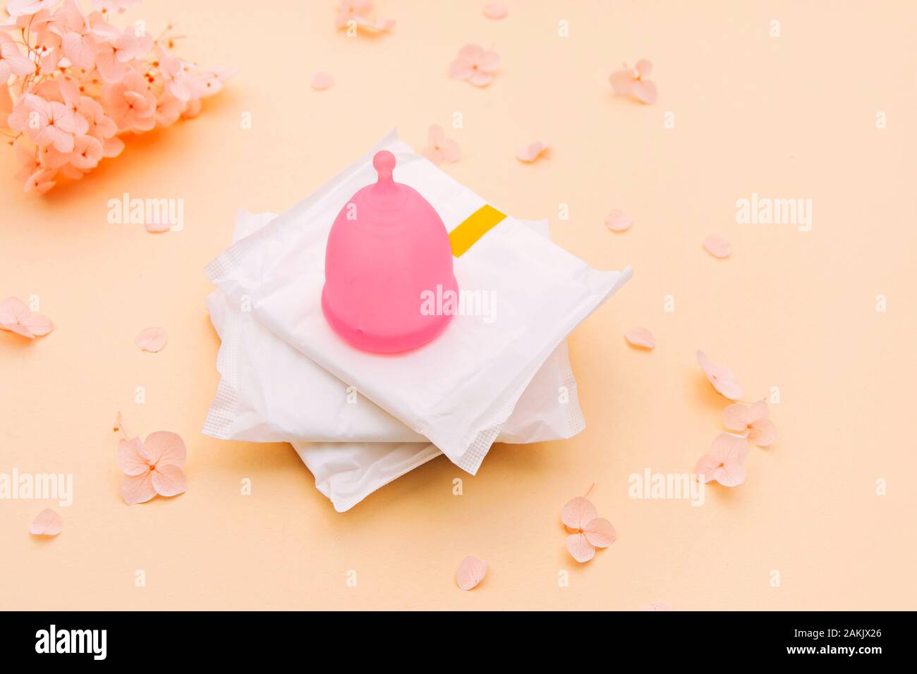 Feminine hygiene products - menstrual cup and sanitary pads on pale orange with hydrangea flowers on it Stock Photo - Alamy