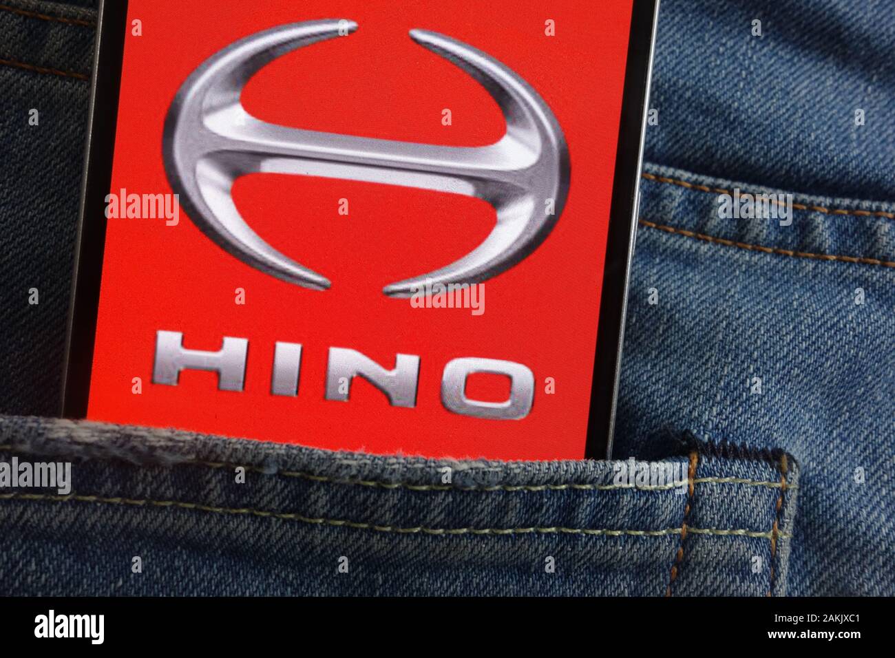 Hino logo displayed on smartphone hidden in jeans pocket Stock Photo