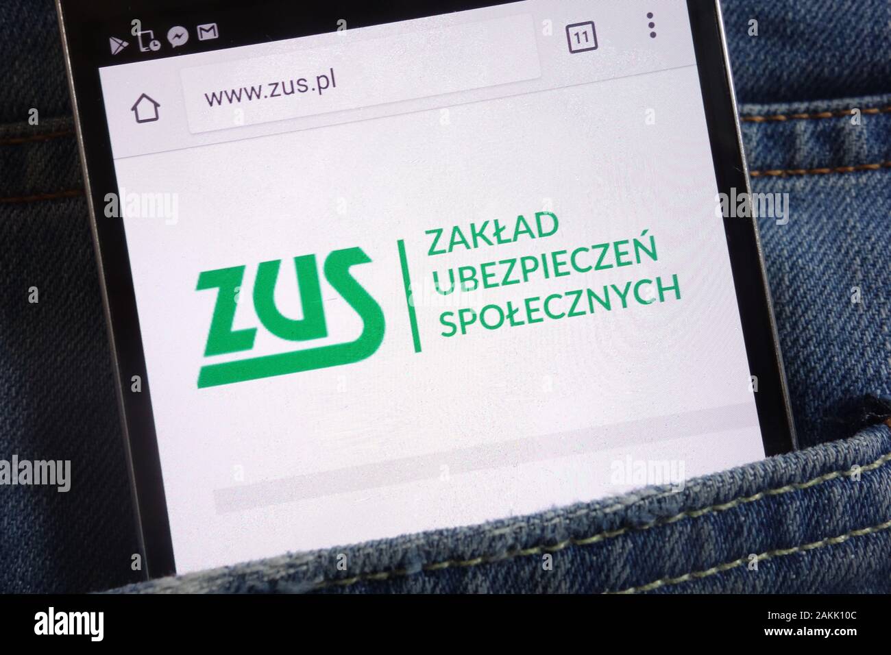 ZUS (Polish social security) website displayed on smartphone hidden in jeans pocket Stock Photo