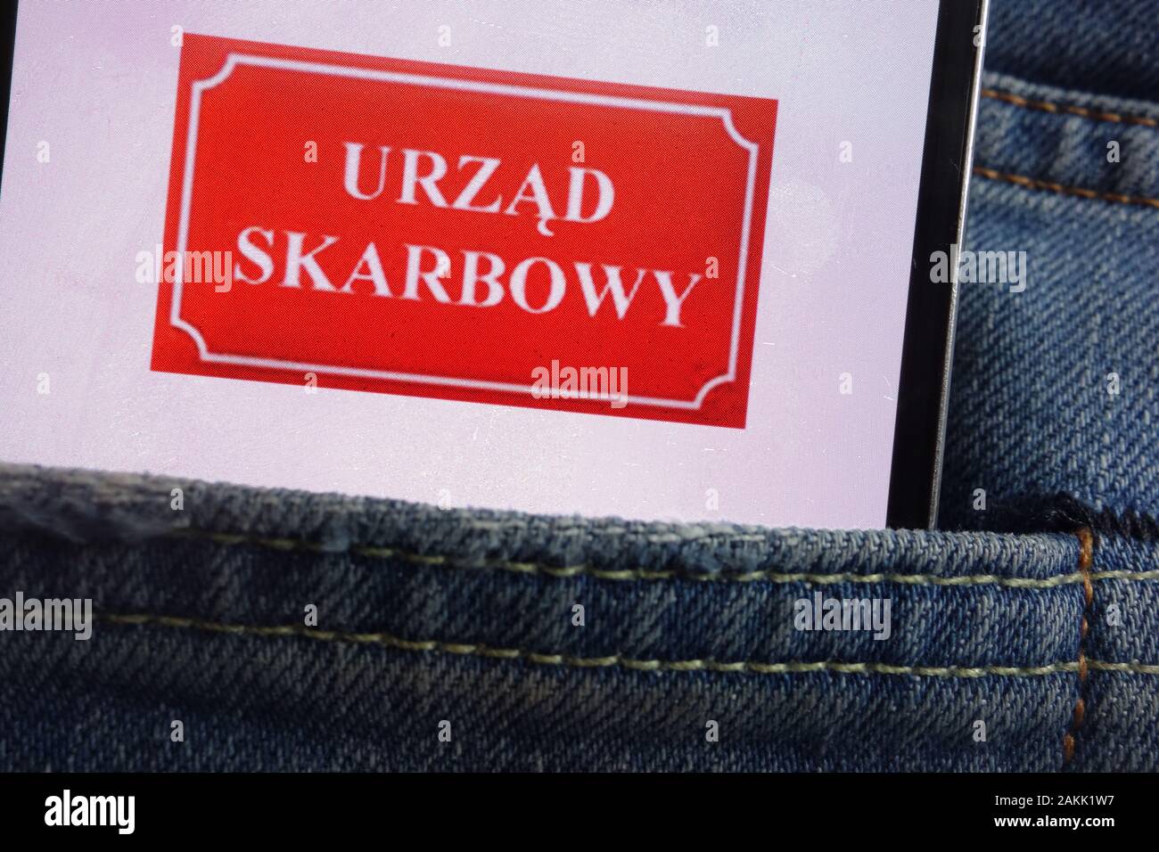 Urzad Skarbowy (Polish Tax Office) logo displayed on smartphone hidden in jeans pocket Stock Photo