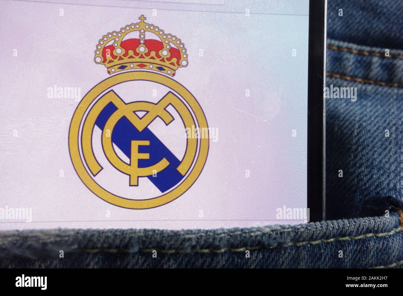 Real Madrid logo displayed on smartphone hidden in jeans pocket Stock Photo