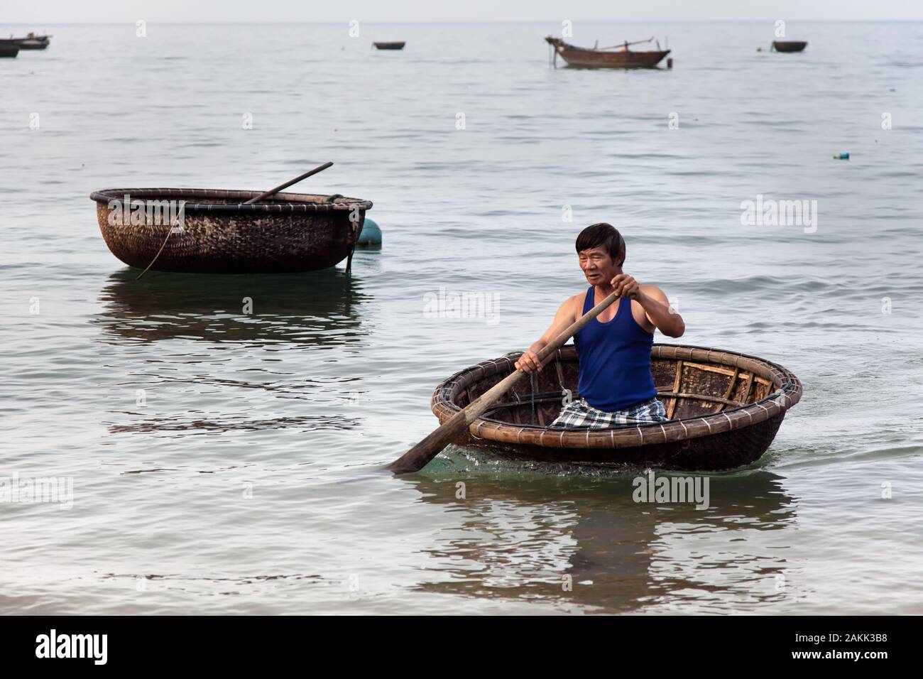 Fisherman in a Traditional circular woven basket boat, Cham Island off