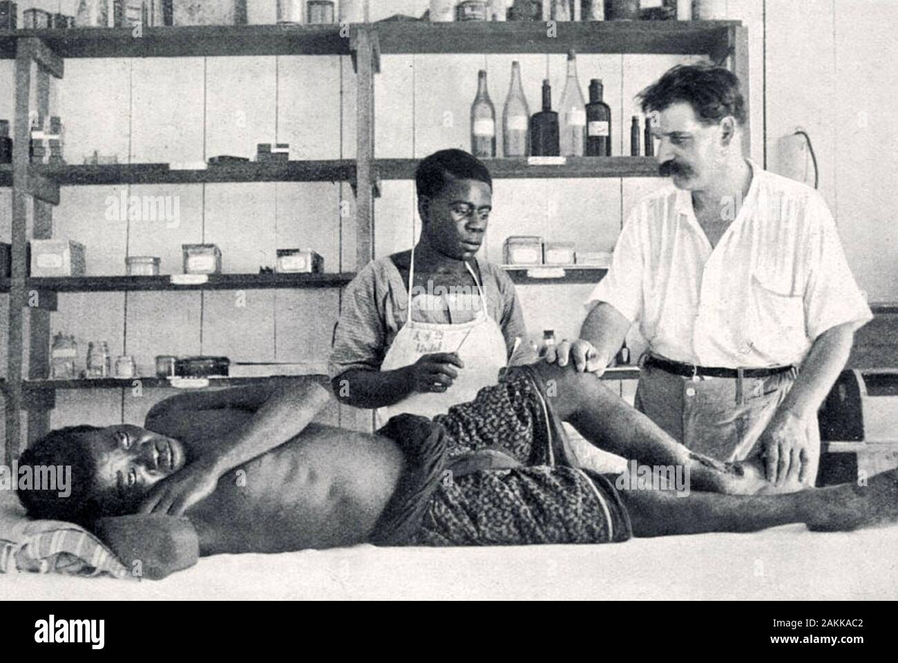 ALBERT SCHWEITZER (1875-1965) Alsatian philosopher,doctor,organist inspecting a wounded patient at his hospital in Lambaréné, now in Gabon. Stock Photo