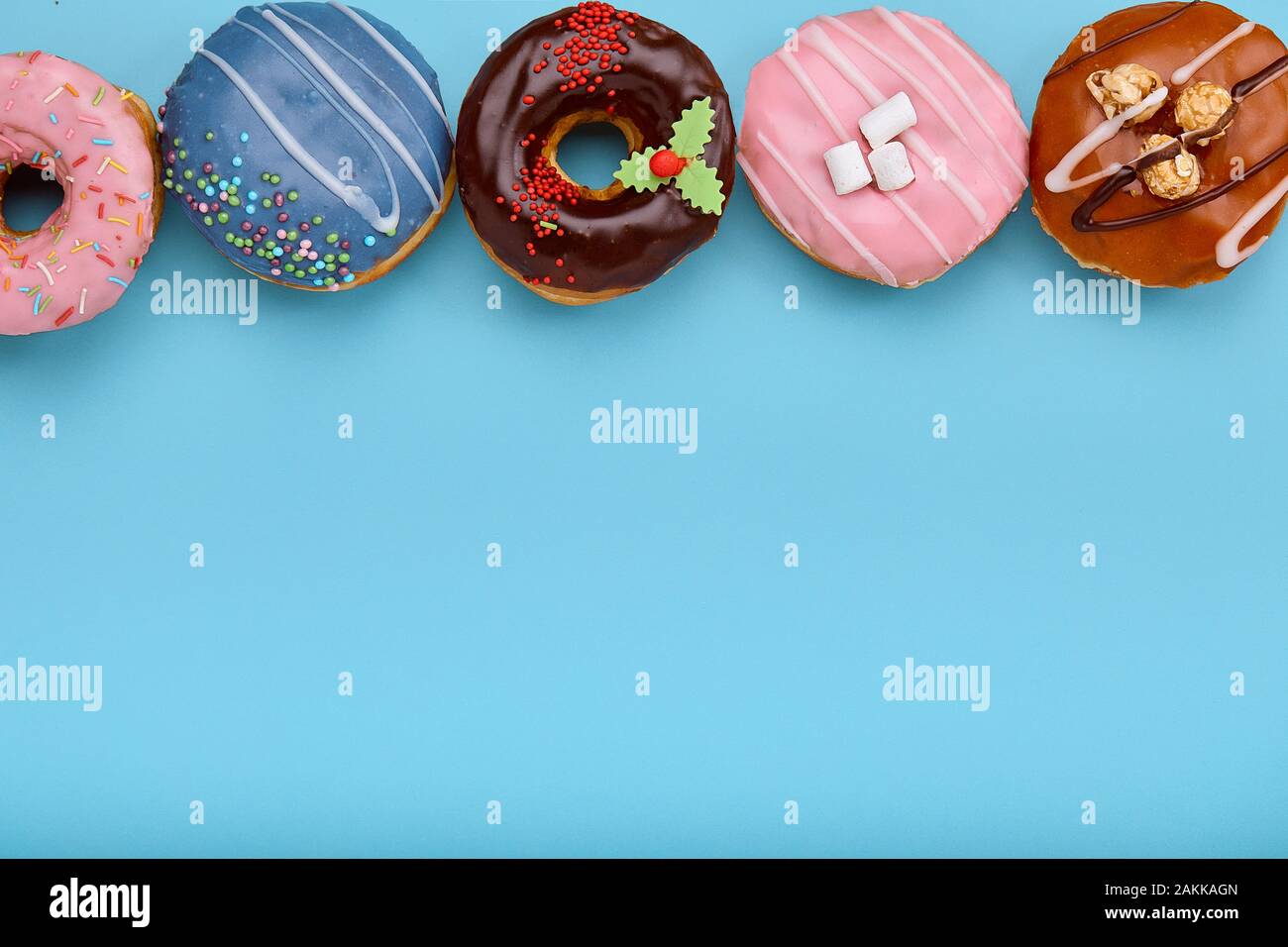 Top view of assorted donuts on blue background with copy space ...