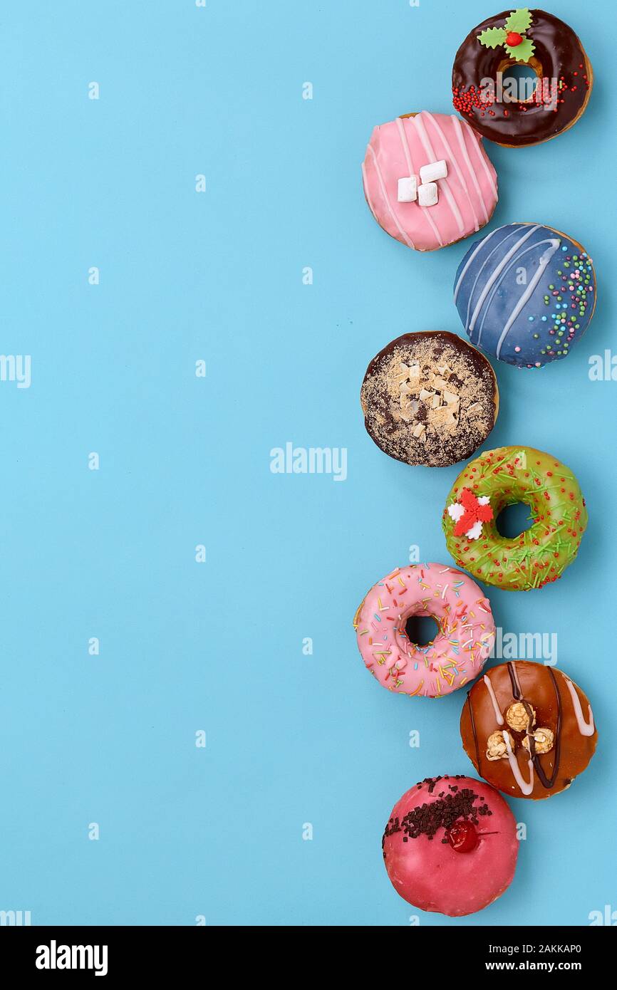 Top view of assorted donuts on blue background with copy space ...