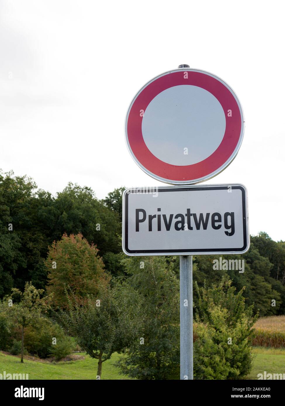 Traffic sign with German text 'Privatweg' translates into 'Private road' in English language Stock Photo