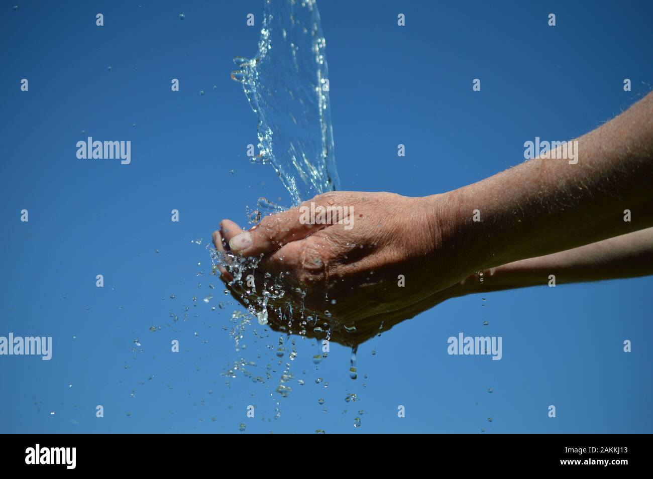 water flowing from the sky into open cupped hands Stock Photo