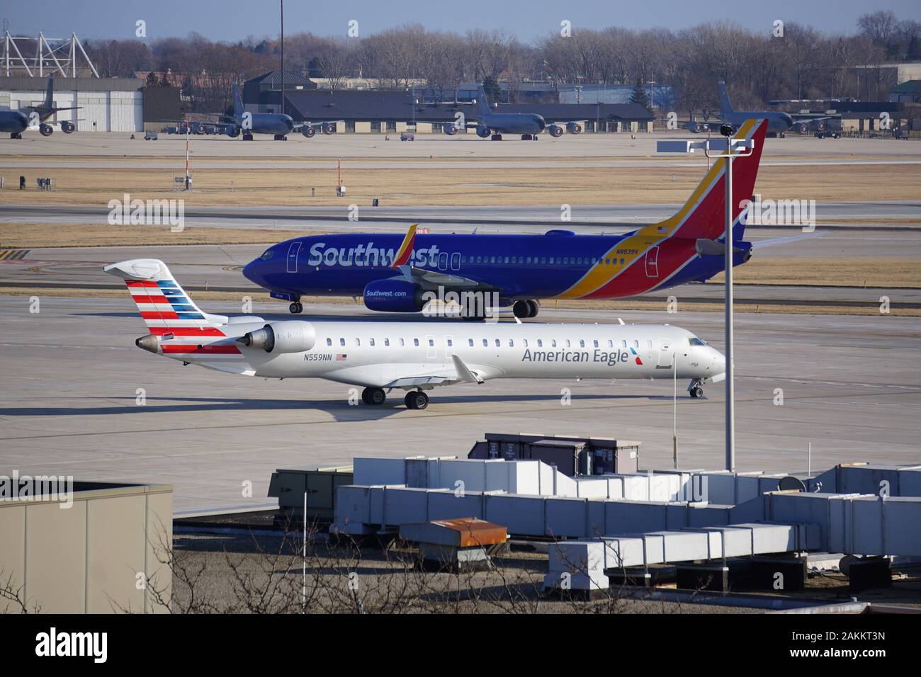 American Eagle Bombardier CRJ and Southwest Airlines Boeing 737 planes pass each other while taxiing at Milwaukee's Mitchell International Airport. Stock Photo