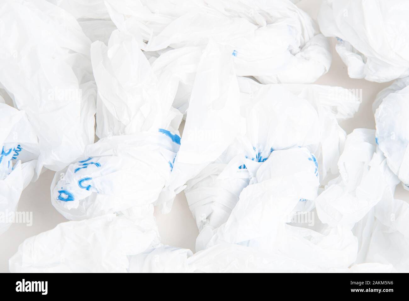 A closeup of a spread of white crumpled grocery labeled plastic bags