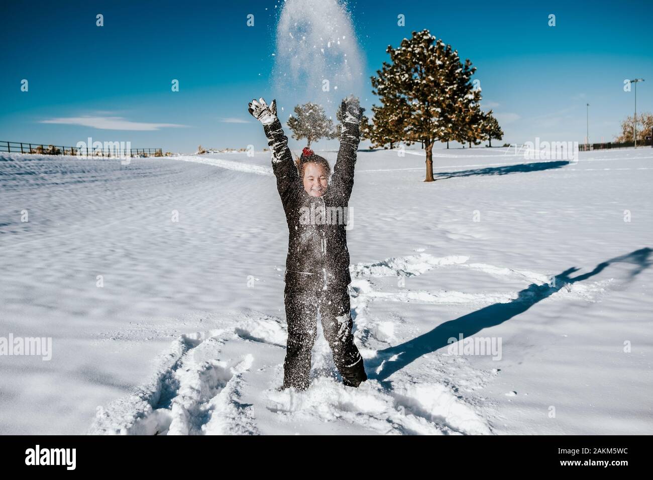 action shot of girl throwing snow in field Stock Photo