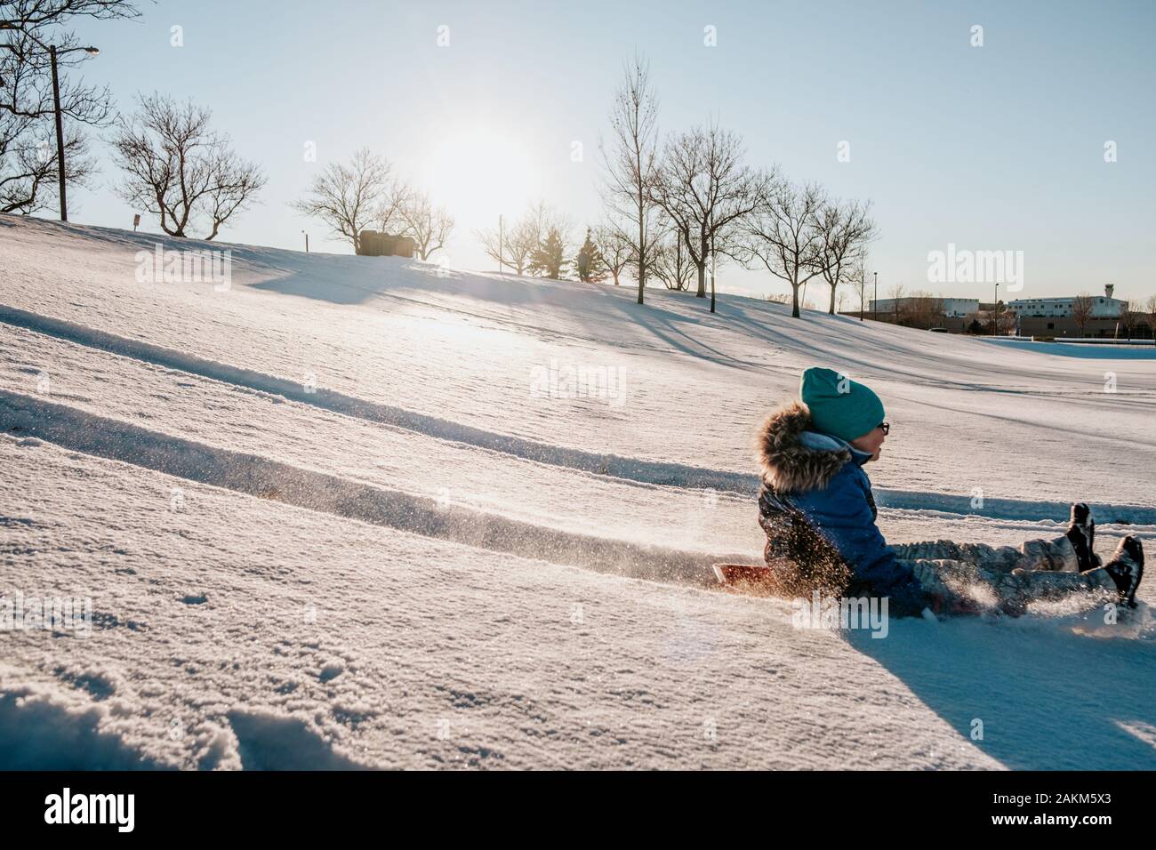 action shot of girl sledding down a hill in winter Stock Photo