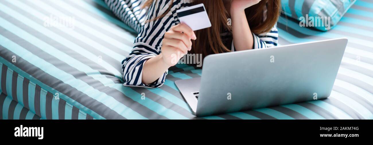 Banner website eautiful of portrait young asian woman lying users credit card with laptop, Content girl shopping online and payment with notebook comp Stock Photo