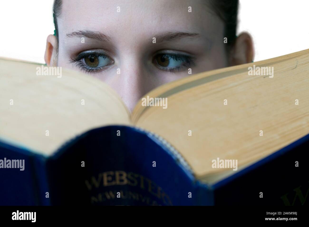 Young female college student reading a very large textbook Stock Photo