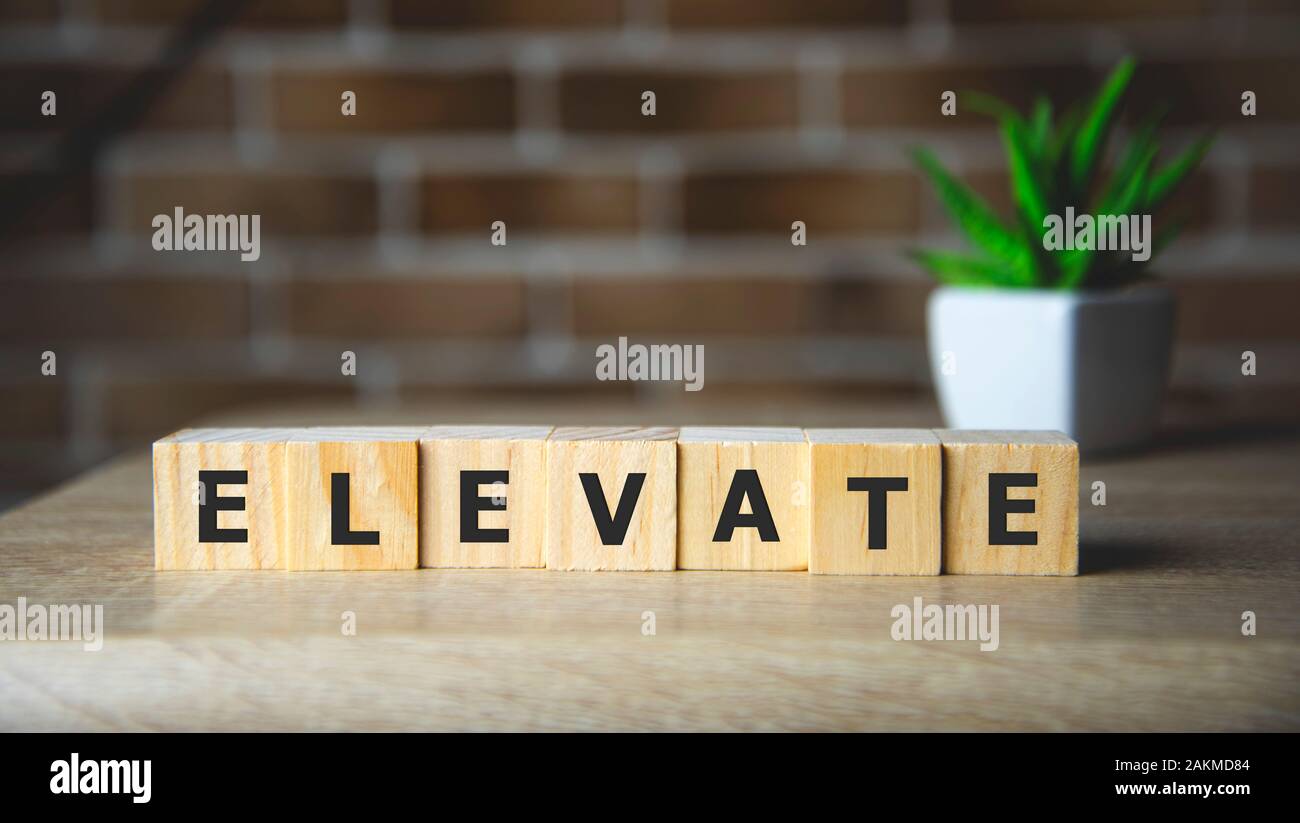 Elevate word written on wood block, business concept. Stock Photo