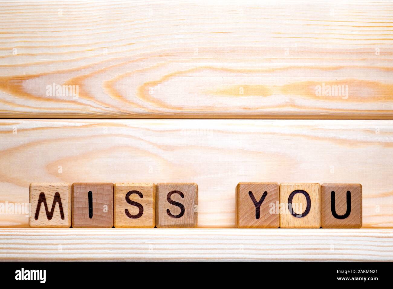 The phrase Miss you. Miss you on wooden cubes. Love theme. Be bored. Be lonely. Valentine's day. Wood letter blocks with words Miss you. Love, positiv Stock Photo