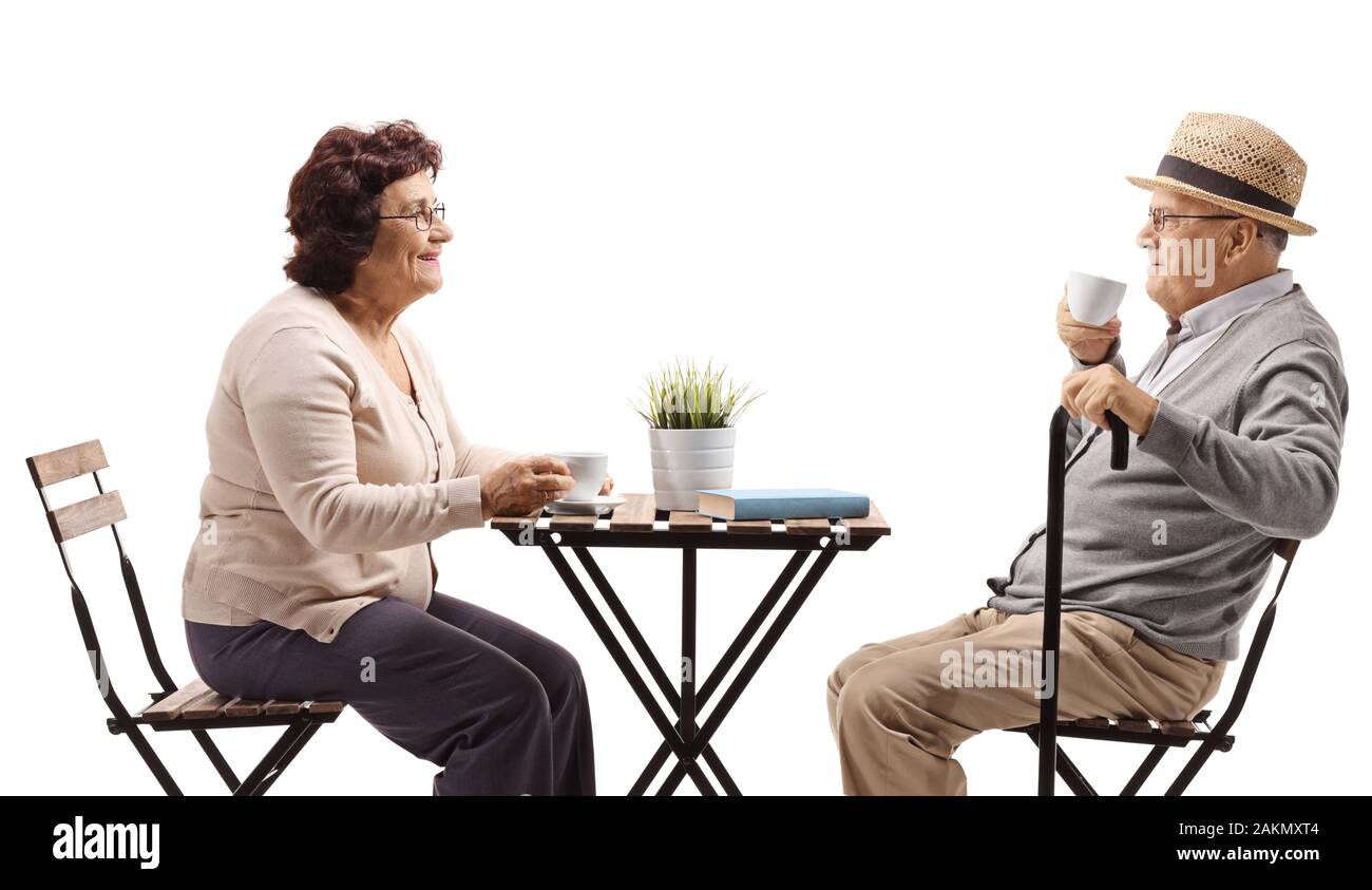 Seniors drinking coffee at a table isolated on white background Stock