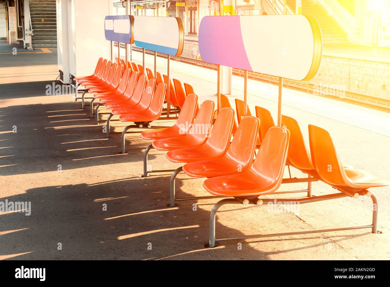 Rows of an empty orange plastic seats in railway station. empty seats. Stock Photo