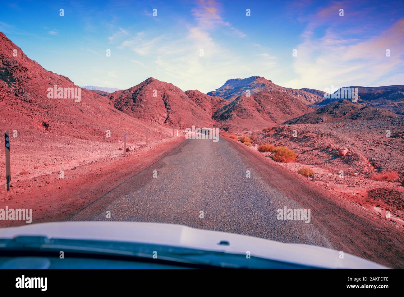 Driving a car on a mountain road in the desert. View of sandstone ...