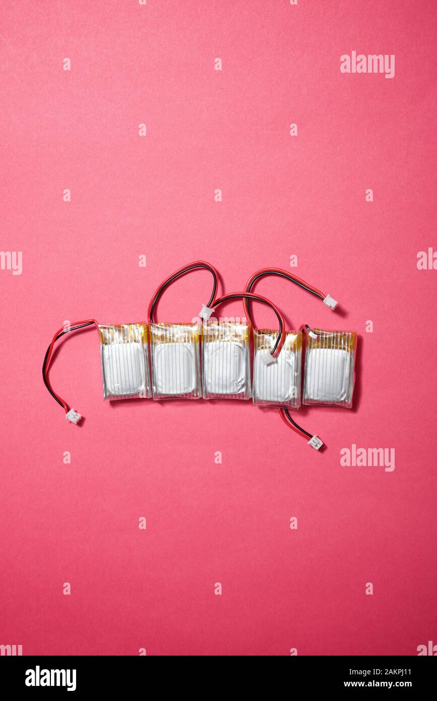 Drone batteries on a pink table. Stock Photo