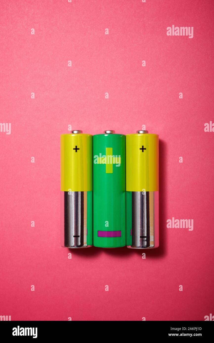 Small batteries on a pink table. Stock Photo