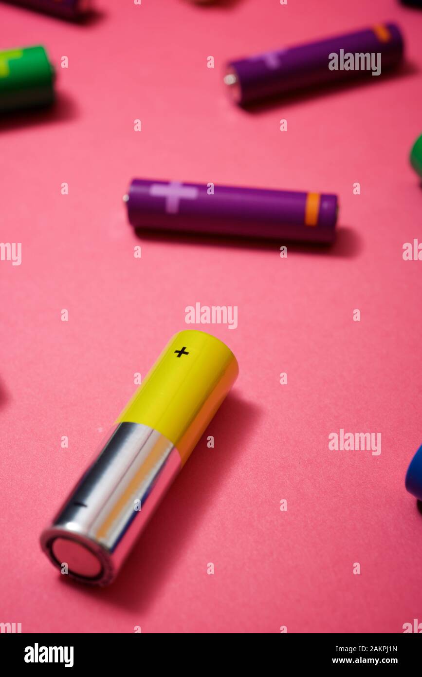 Many batteries on a pink table. Stock Photo
