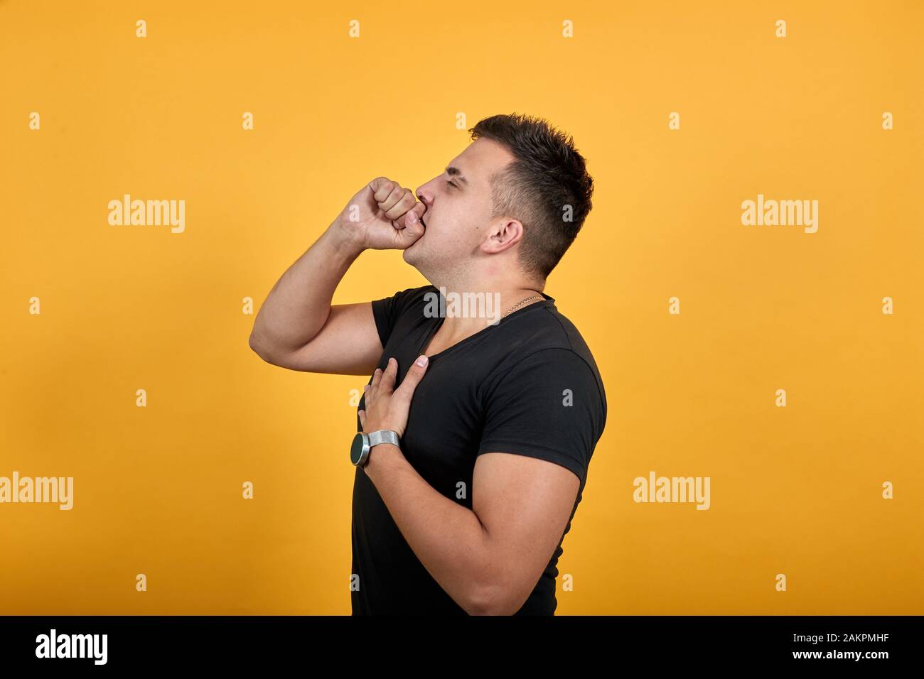Sickness young man covered mouth with hand, cough, keeping hand on chest. Stock Photo