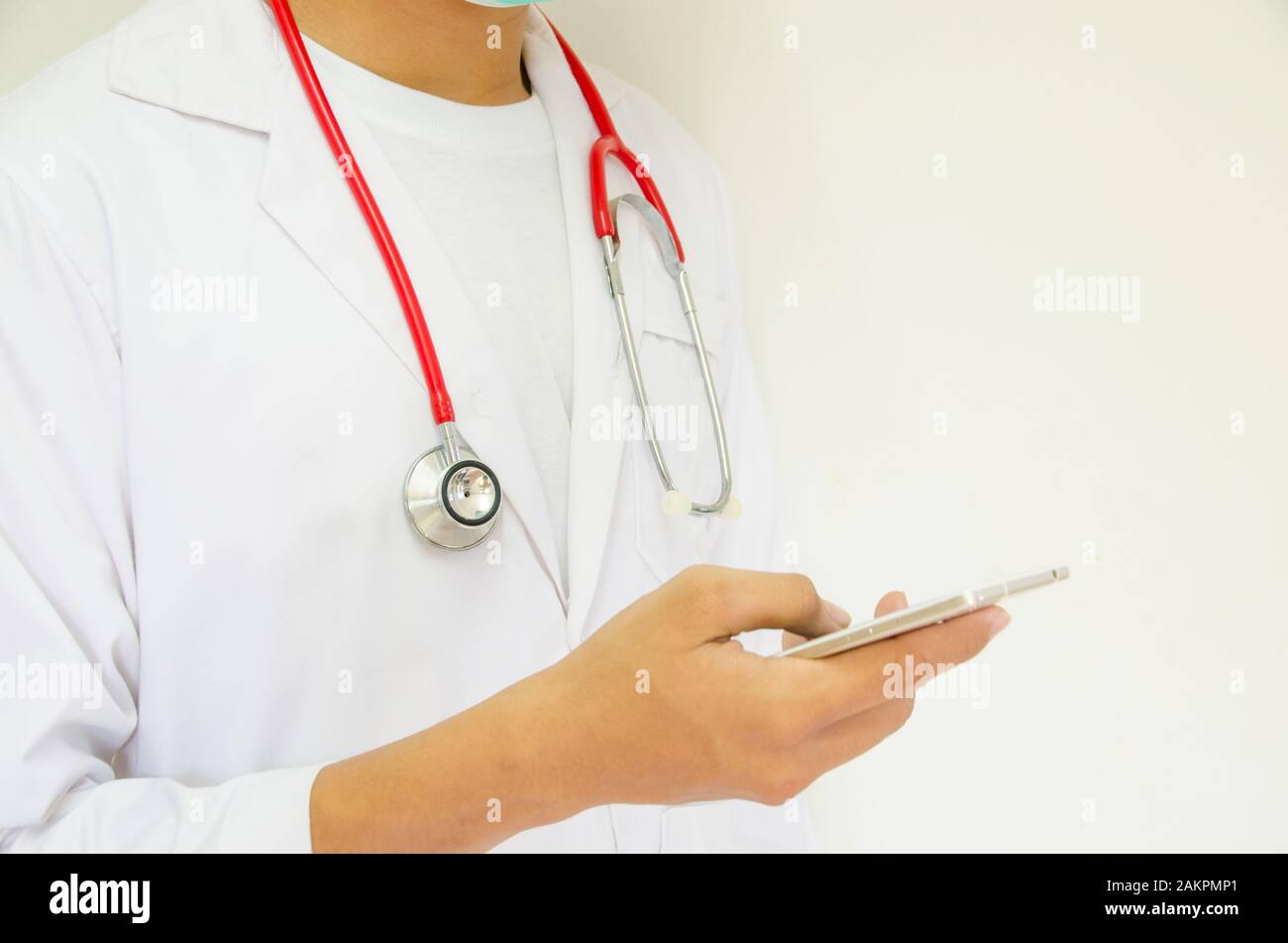 Doctor Holding Smartphone On White Background Focus On Stethoscope doctor-holding-smartphone-on-white-background-focus-on-stethoscope