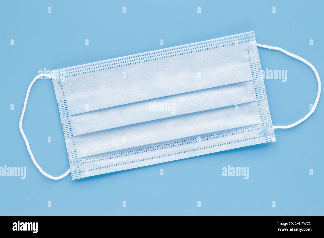 Surgical mask with rubber ear straps. Typical 3-ply surgical mask to cover the mouth and nose. Procedure mask from bacteria. Protection concept Stock Photo