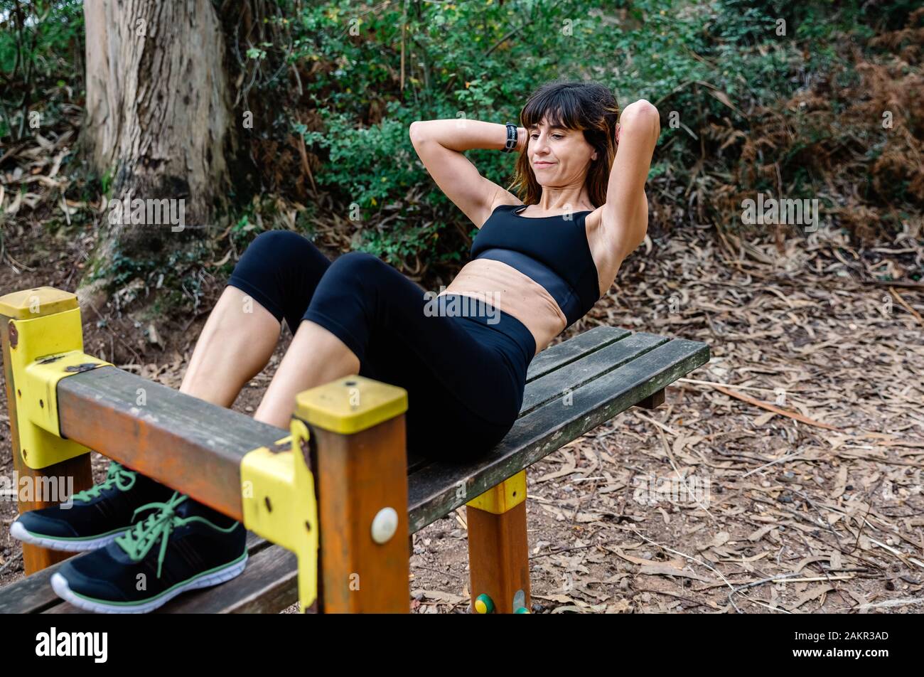 Sportswoman training on an abdominal bench Stock Photo