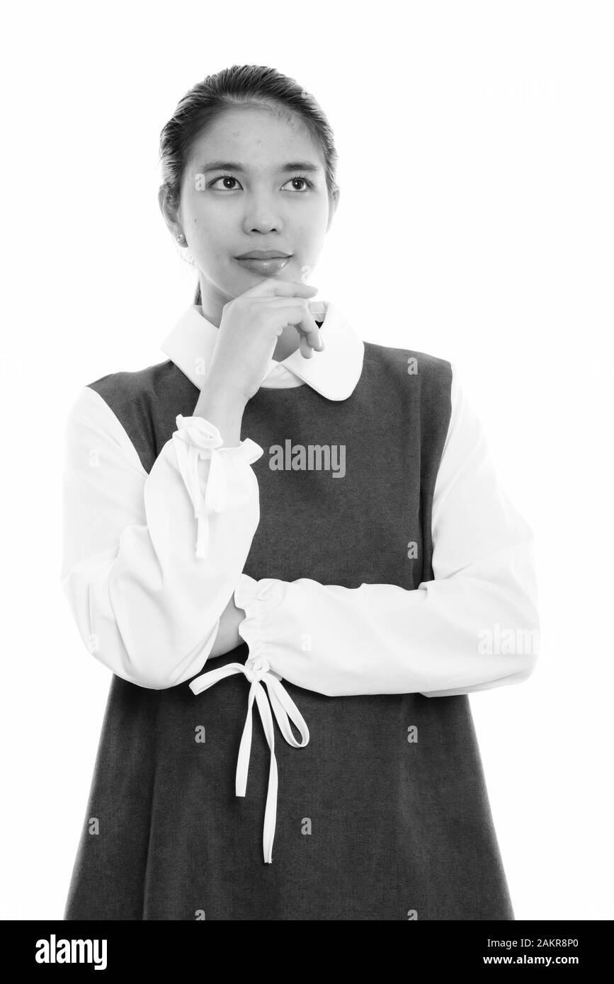 Studio shot of young Asian woman thinking Stock Photo - Alamy