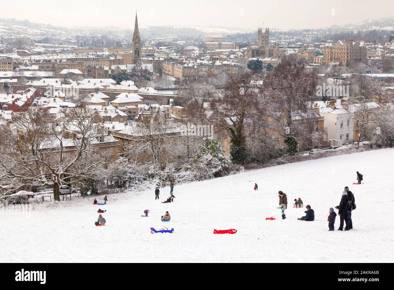 BATH, UNITED KINGDOM - DECEMBER 18, 2010 : People sledding on Bathwick Hill in the snow, with the historic City of Bath in the background. Stock Photo