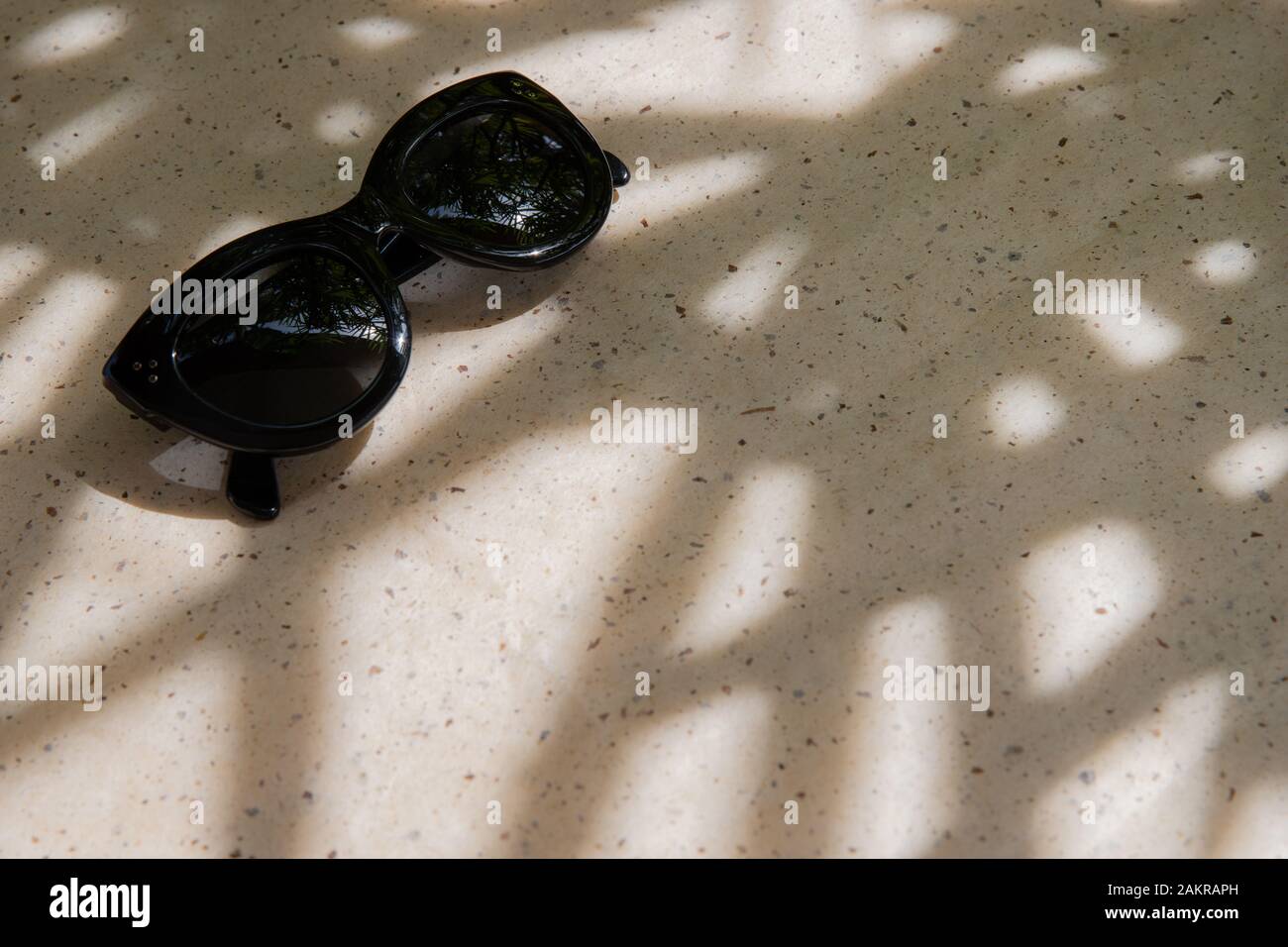 Summer composition with sunglasses and palm leaf shadows Stock Photo