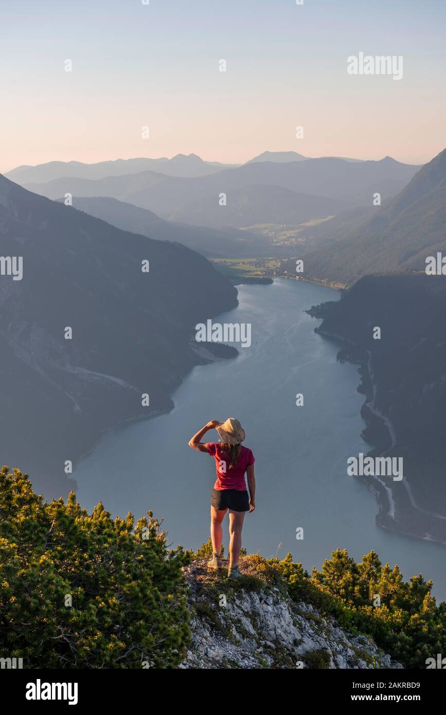 Young woman looking over mountain landscape, view from the mountain Baerenkopf to Lake Achensee, Tyrol, Austria Stock Photo