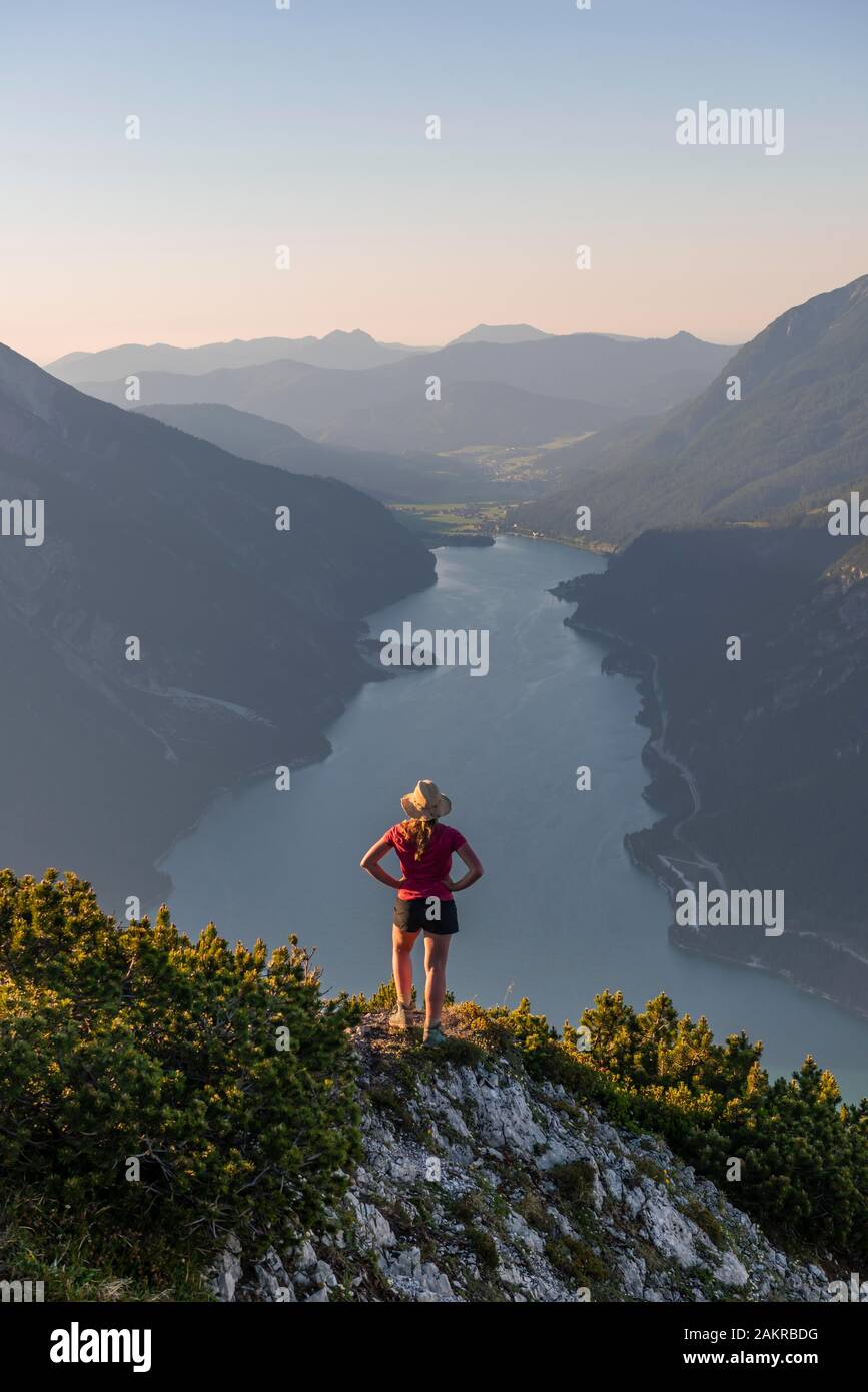 Young woman looking over mountain landscape, view from the mountain Baerenkopf to Lake Achensee, Tyrol, Austria Stock Photo