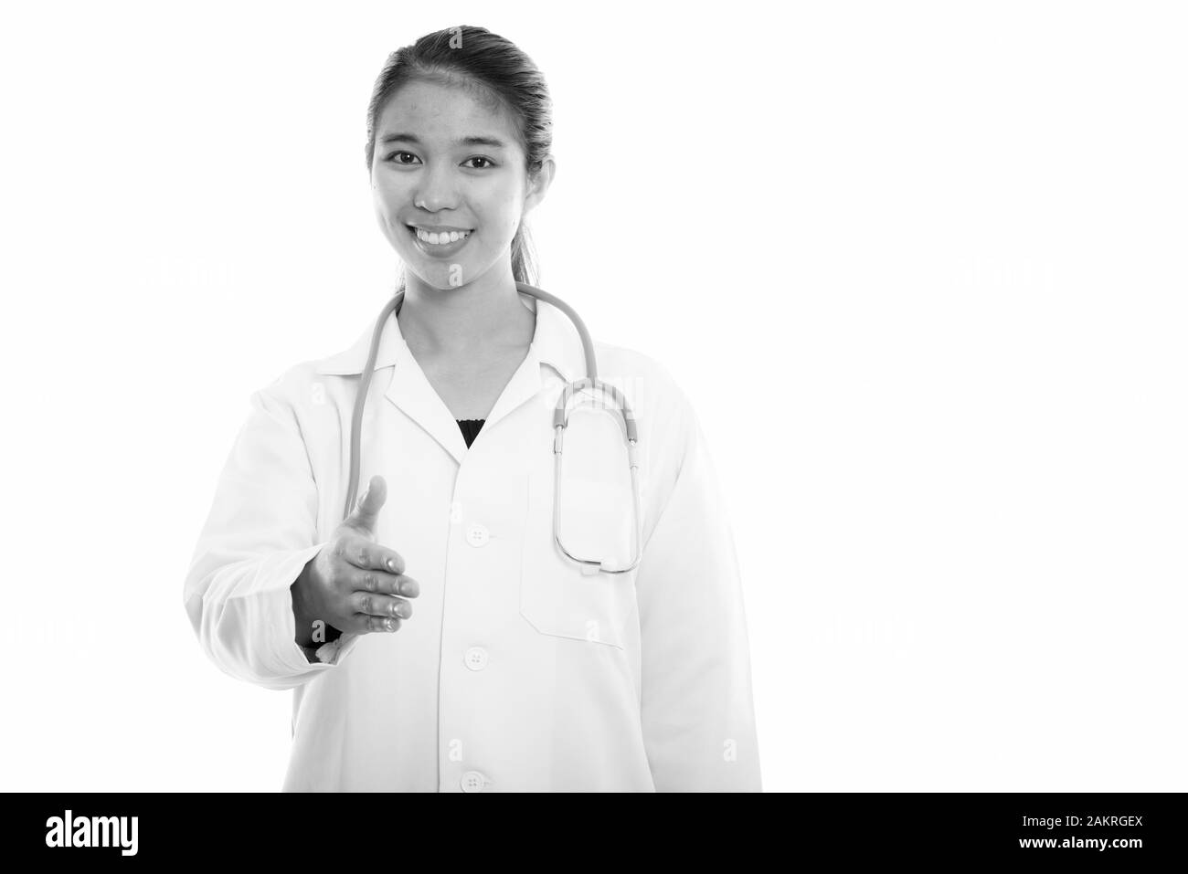 Studio shot of young happy Asian woman doctor smiling while giving ...