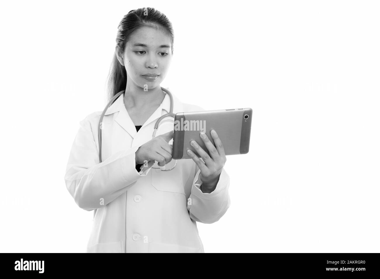 Studio shot of young Asian woman doctor using digital tablet Stock Photo