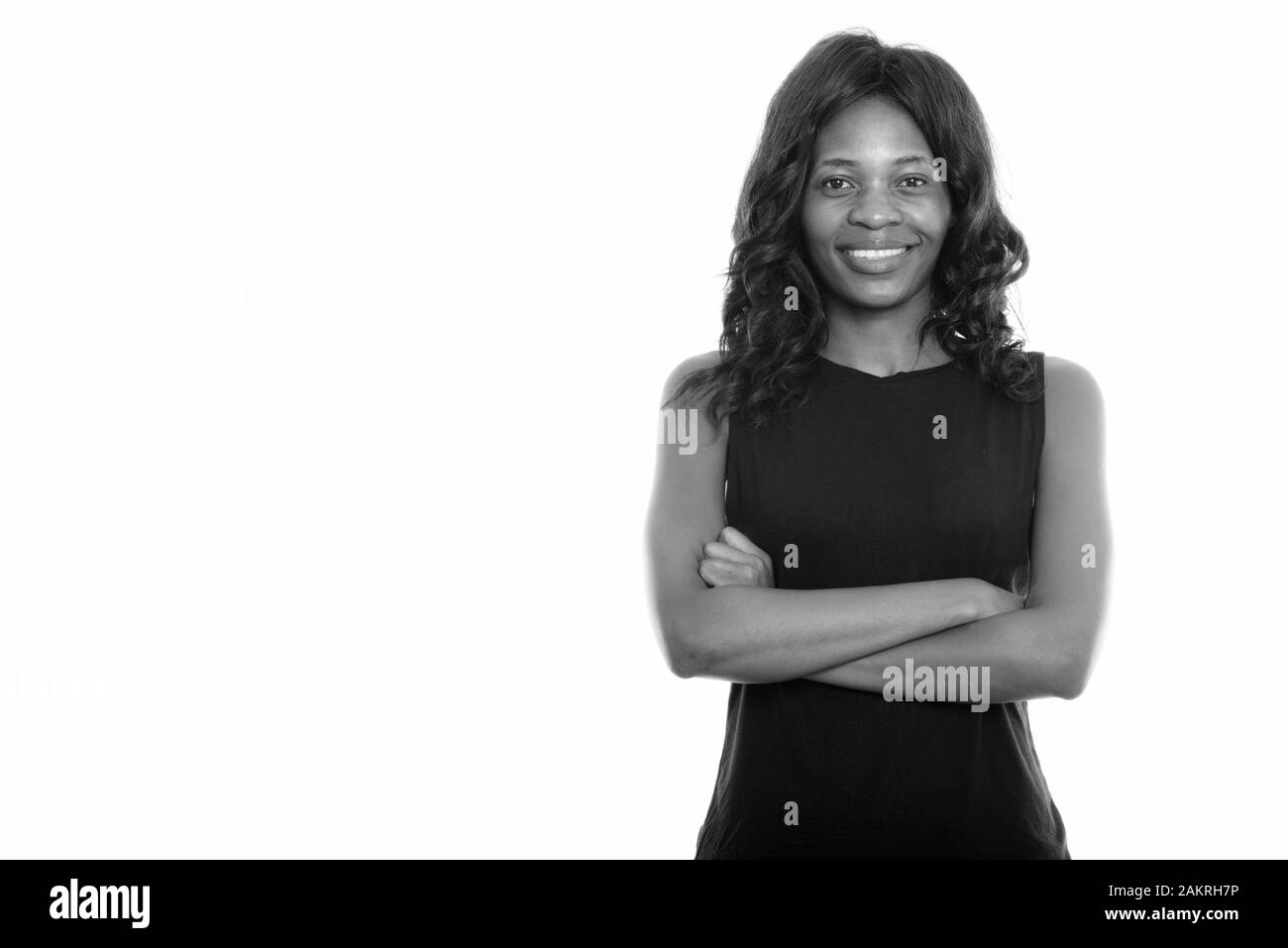 Studio shot of young happy black African woman smiling with arms ...