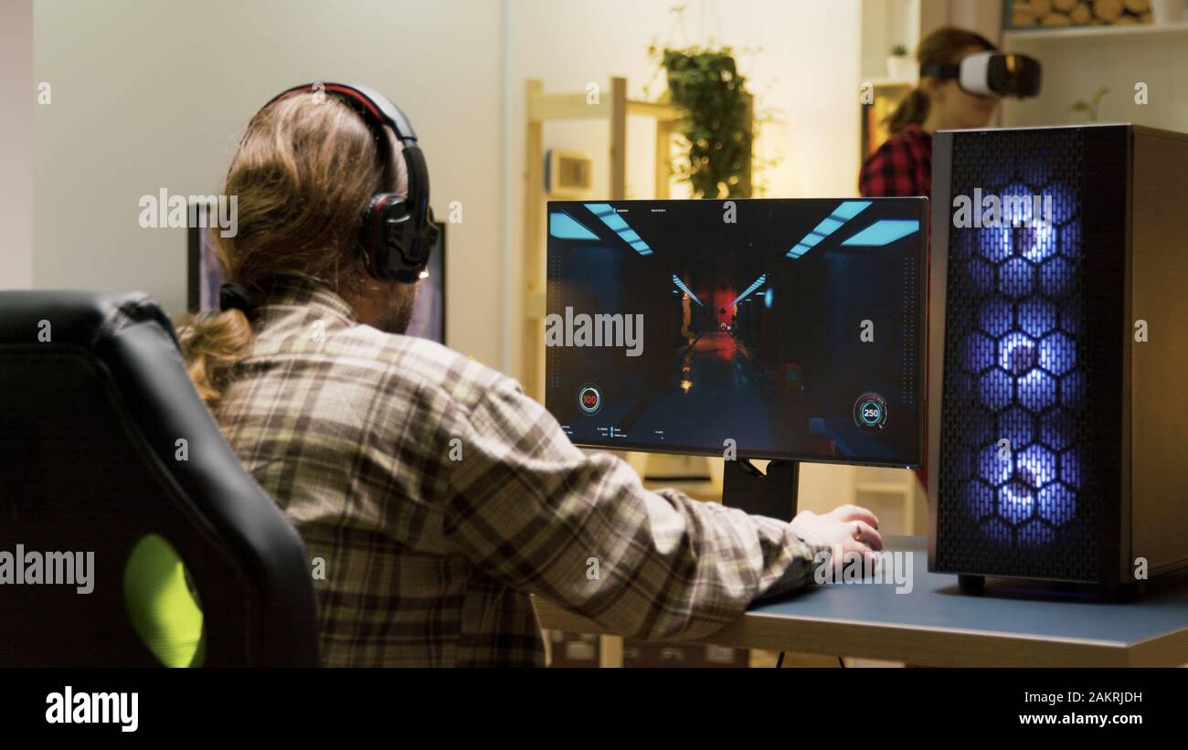 Man keeping his head on desk after losing at video games on computer. Game over for male gamer. Stock Photo