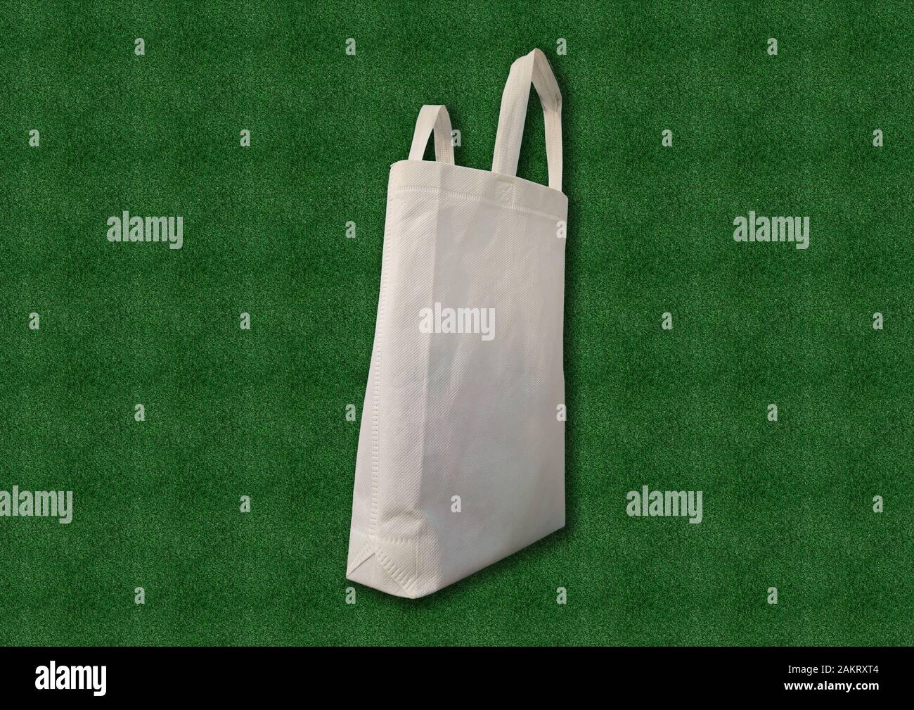 https://c8.alamy.com/comp/2AKRXT4/white-fabric-cloth-recyclable-eco-bag-on-green-grass-background-replacement-plastic-bag-save-earth-ecology-non-woven-bag-good-for-the-environment-2AKRXT4.jpg