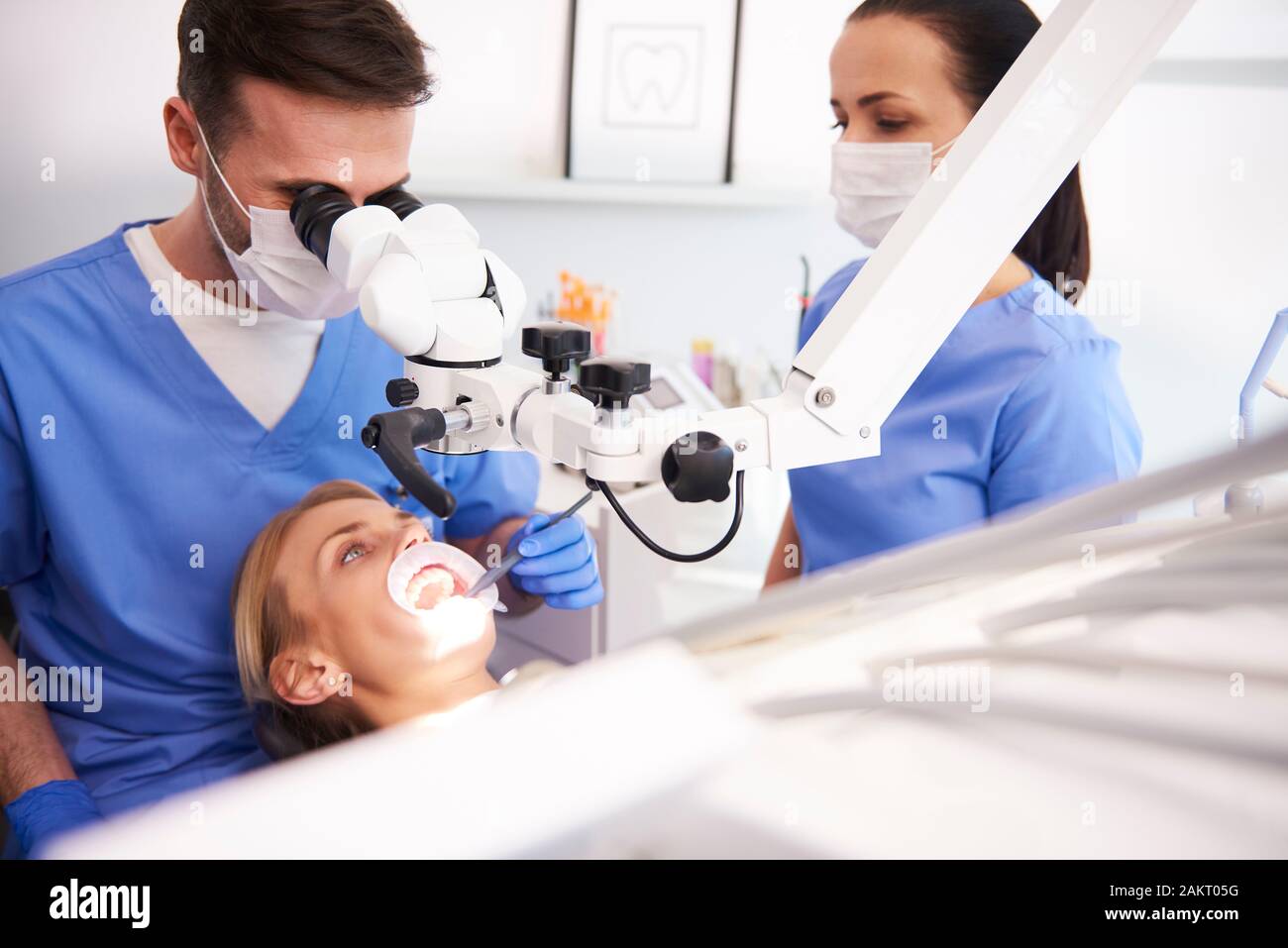 Male dentist looking through dental microscope Stock Photo