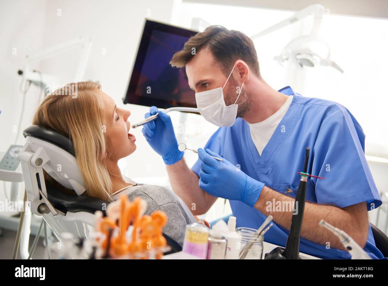 Focused dentist using dental drill and dental mirror Stock Photo - Alamy