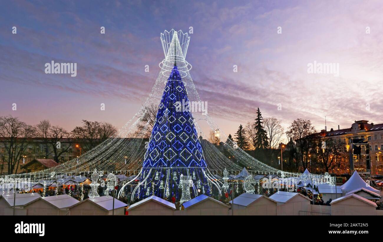VILNIUS, LITHUANIA - DECEMBER 29, 2019: Christmas European  city square awith  decorated illuminate fir tree in big Chess style on  European old town. Stock Photo