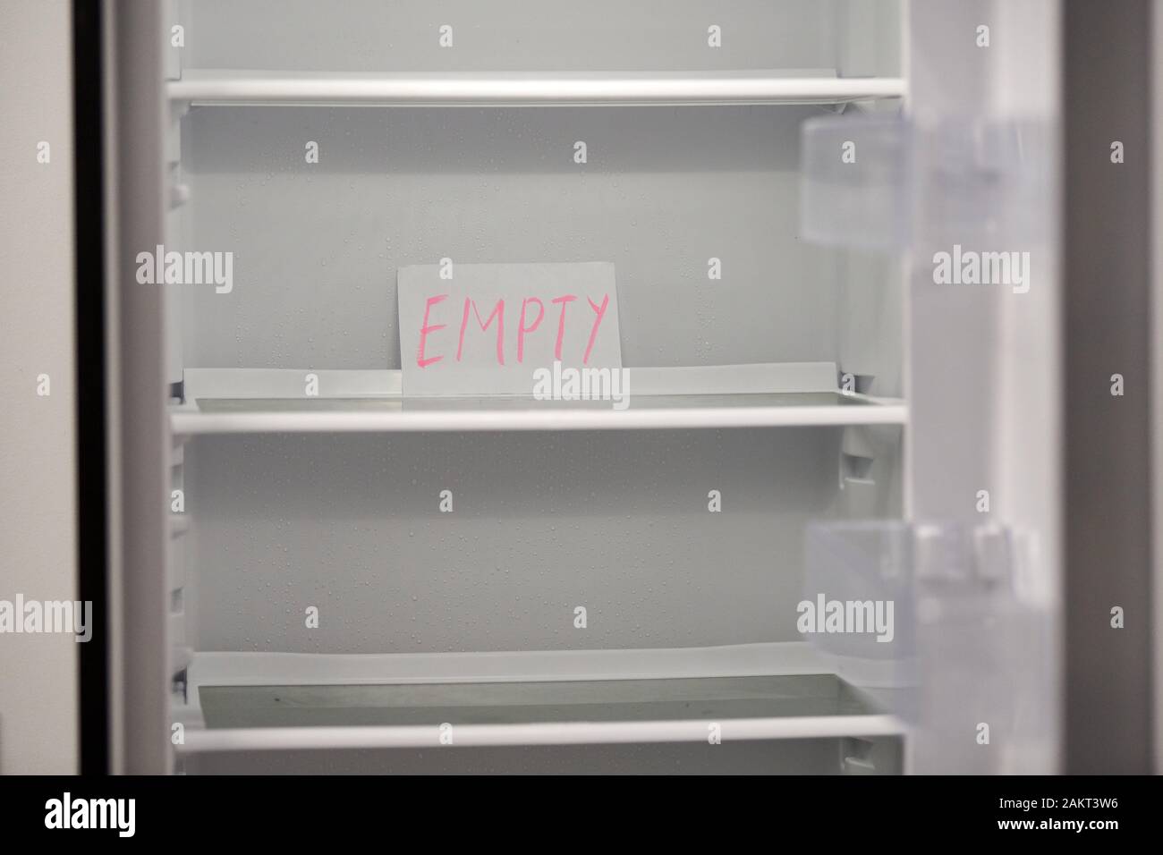 Empty refrigerator concept. Empty shelves of new refrigerator. Weight