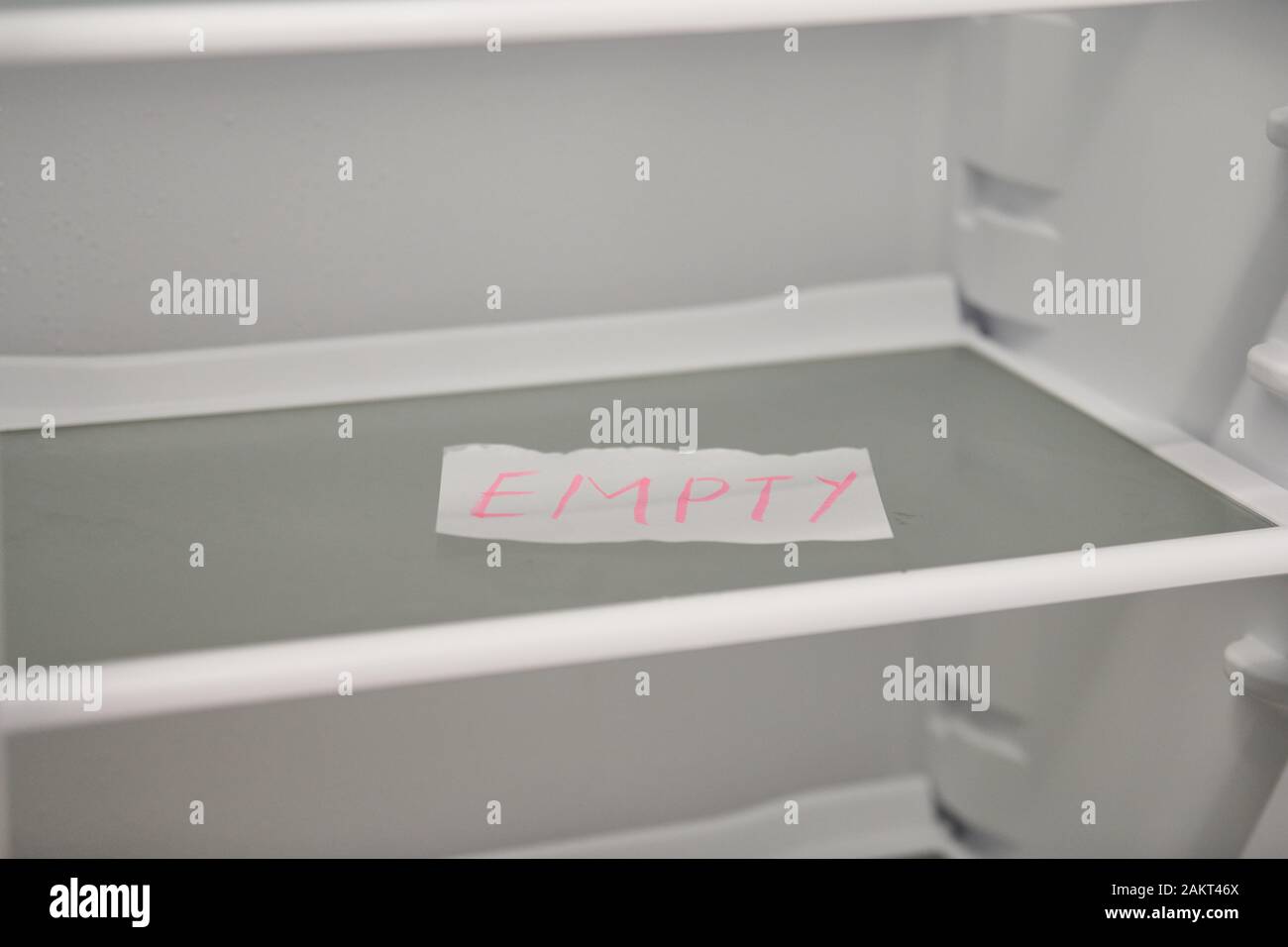 Empty refrigerator concept. Empty shelves of new refrigerator. Weight
