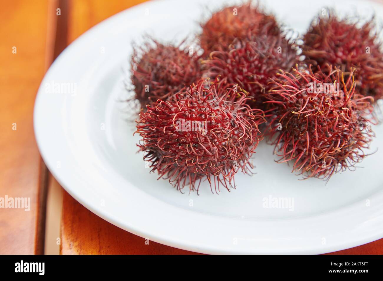 A plate of Rambutans, a spiky red fruit. Stock Photo