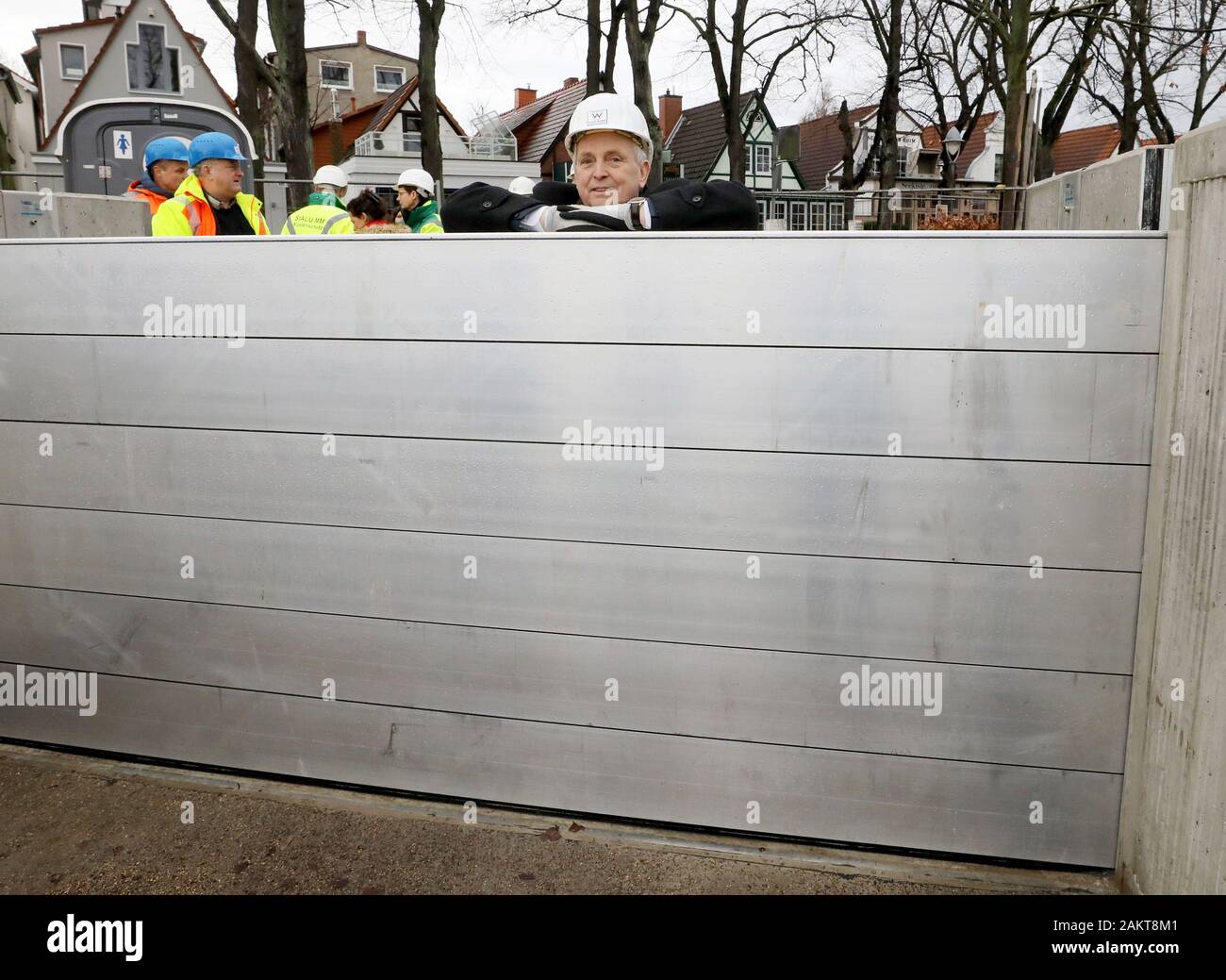 10 January 2020, Mecklenburg-Western Pomerania, Warnemünde: Till Backhaus (SPD, M), Minister for the Environment of the federal state of Baden-Württemberg, looks over a dam beam after the handover of the new storm surge protection wall at the southern Alter Strom after the construction of a dam beam closure, with which passages in the wall can be closed off if necessary. The structure, which is around 500 metres long, is 2.75 metres high and can therefore withstand water levels of up to 2.50. Due to the modular construction it is possible to raise the wall. Photo: Bernd Wüstneck/dpa-Zentralbil Stock Photo