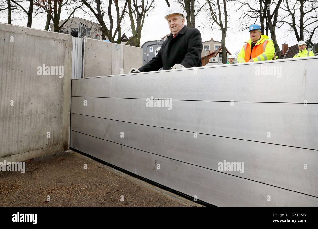 10 January 2020, Mecklenburg-Western Pomerania, Warnemünde: Till Backhaus (SPD, l), Minister for the Environment of the federal state of Lower Saxony, is standing at a dam beam after the handover of the new storm surge protection wall at the southern Alter Strom after the construction of a dam beam closure, with which passages in the wall can be closed off if necessary. The structure, which is around 500 metres long, is 2.75 metres high and can therefore withstand water levels of up to 2.50. Due to the modular construction it is possible to raise the wall. Photo: Bernd Wüstneck/dpa-Zentralbild Stock Photo